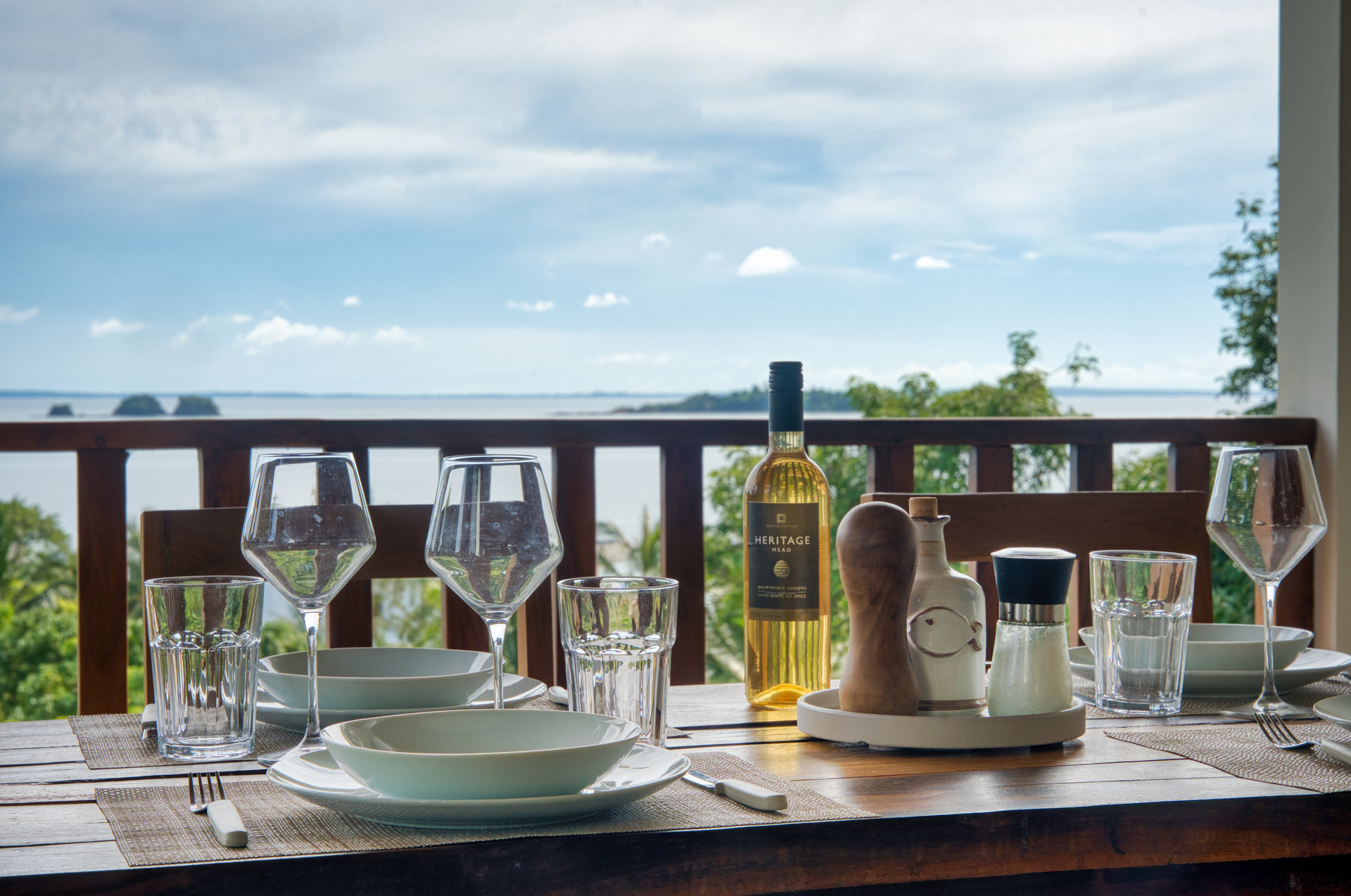 Superior Family Suite outdoor dining table set with wine glasses and panoramic ocean view